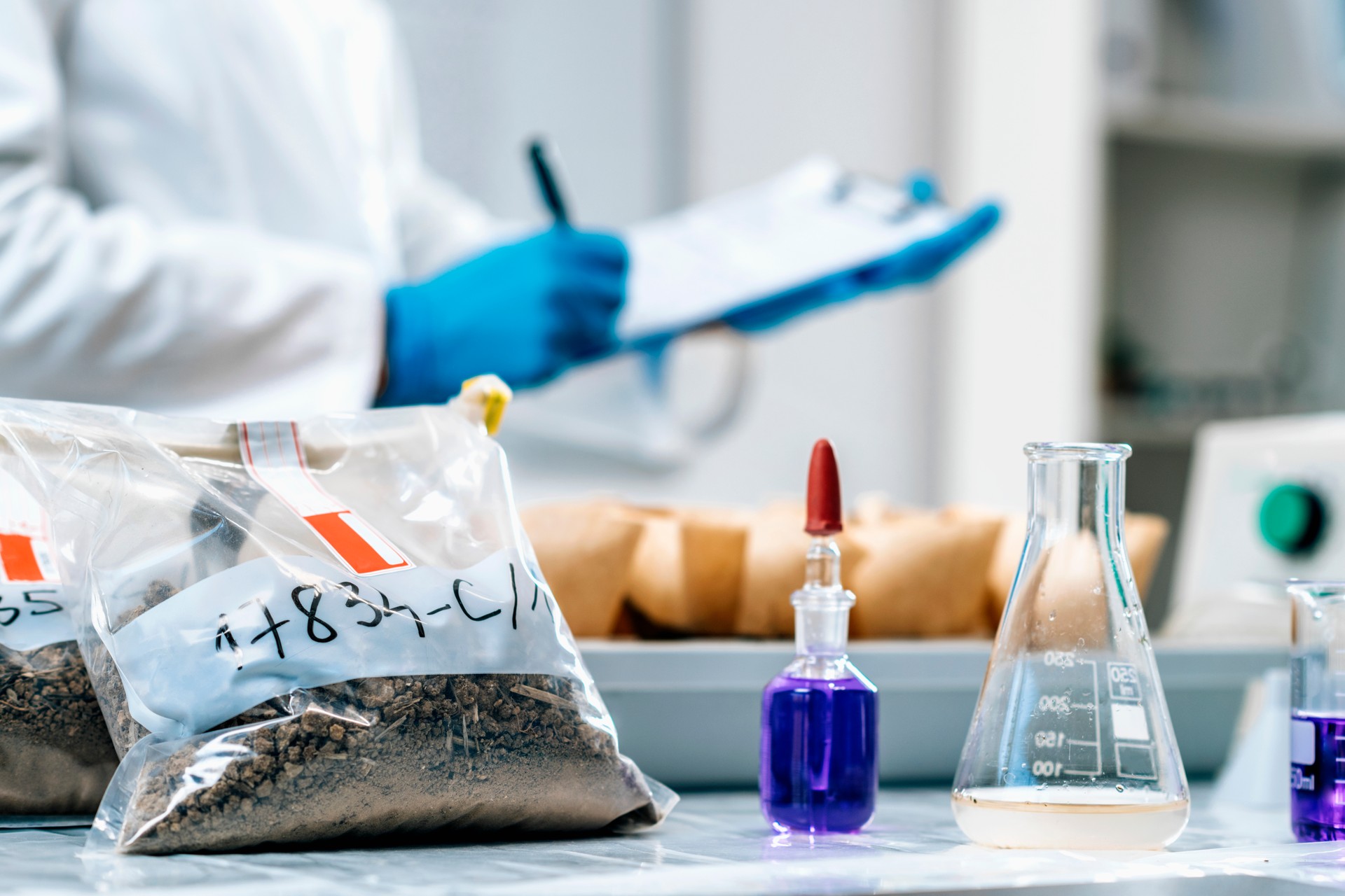 Soil Samples Testing Laboratory. Female Biologist Taking Notes In Laboratory